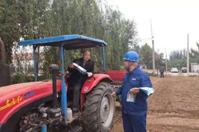 向正在田間耕種的村民講解保護(hù)電力設(shè)施的重要性